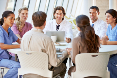 Medical Team Discussing Treatment Options With Patients Round A Table